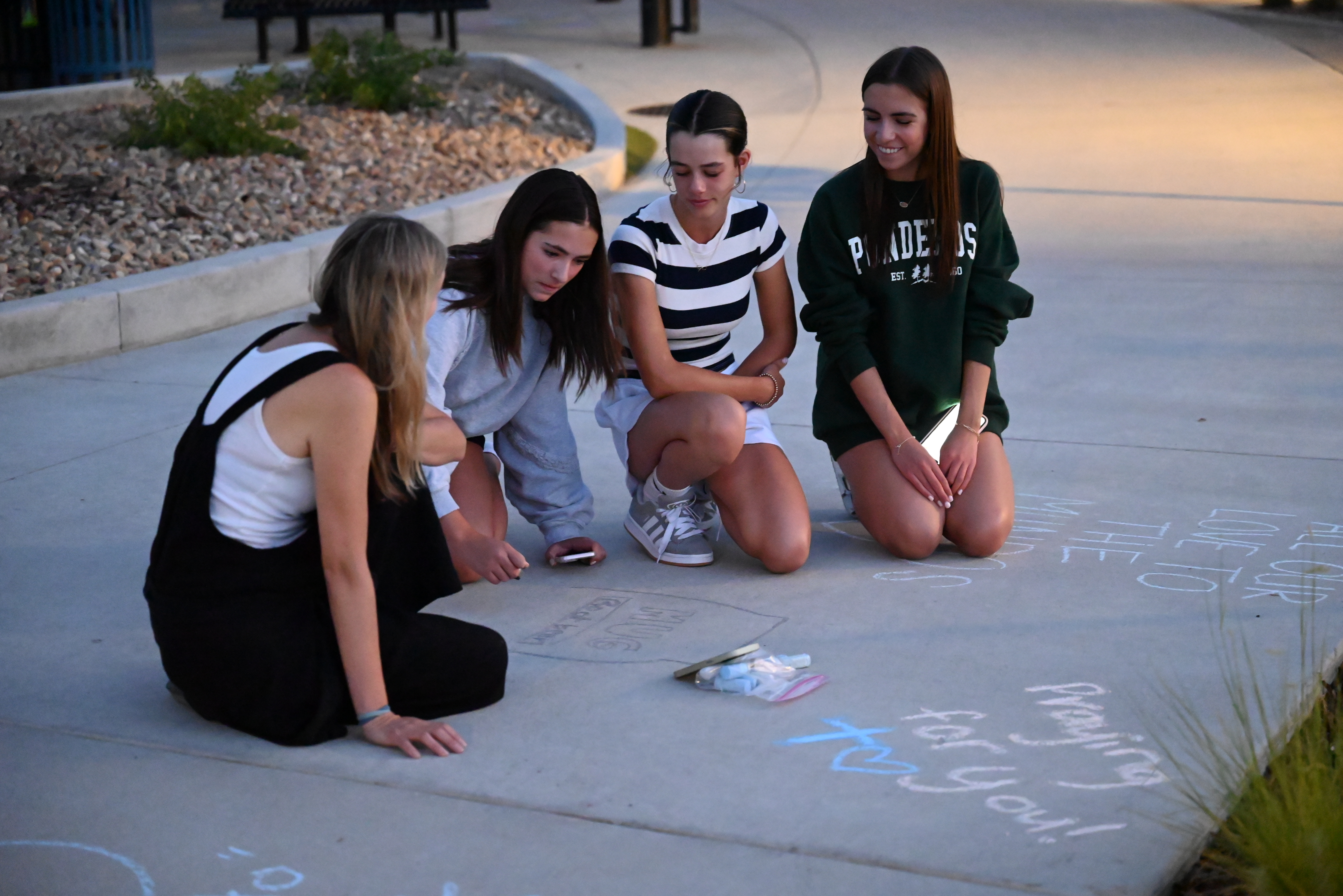Students writing chalk tributes